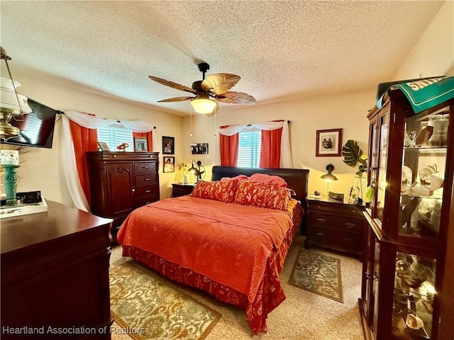 bedroom featuring a textured ceiling, a ceiling fan, and carpet flooring