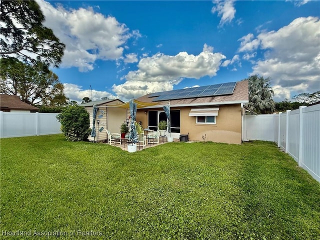 rear view of property with a patio, a yard, a fenced backyard, and stucco siding