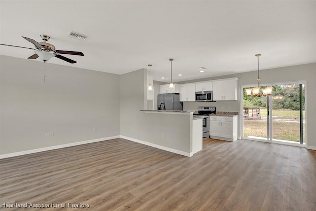 kitchen featuring white cabinetry, dark wood-type flooring, stainless steel appliances, pendant lighting, and ceiling fan with notable chandelier