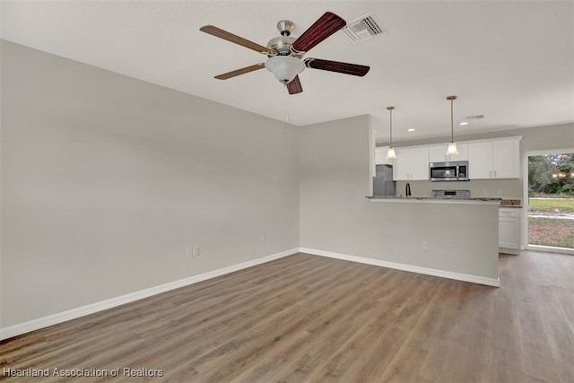 unfurnished living room with hardwood / wood-style flooring and ceiling fan