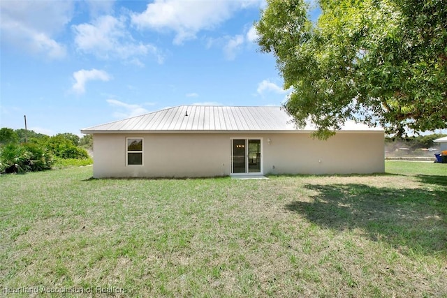 rear view of property featuring a yard