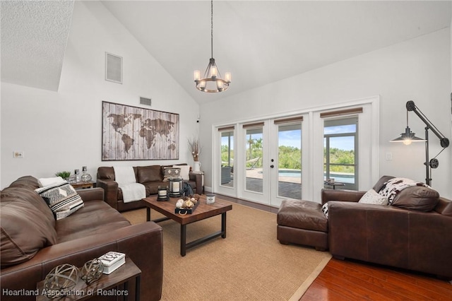509 Bear Rd, Lake Placid, FL 33852 - living room with high vaulted ceiling, wood finished floors, a chandelier, plenty of natural light, and french doors