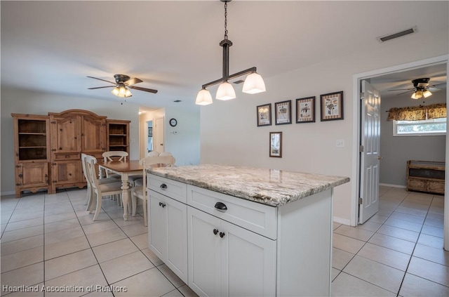 400 Spring Blvd, Sebring, FL 33876 - kitchen with ceiling fan, light tile patterned floors, white cabinets, and a kitchen island