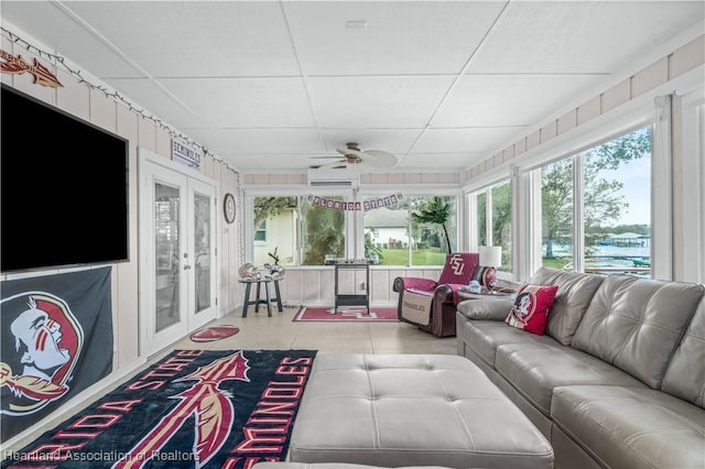 living room with a wall mounted air conditioner, a paneled ceiling, ceiling fan, and french doors