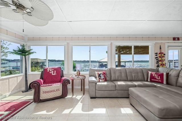 tiled living room featuring a water view and ceiling fan