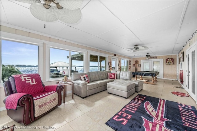 sunroom / solarium with a water view and ceiling fan