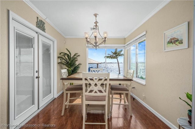 dining room featuring dark wood-type flooring, a wealth of natural light, and ornamental molding