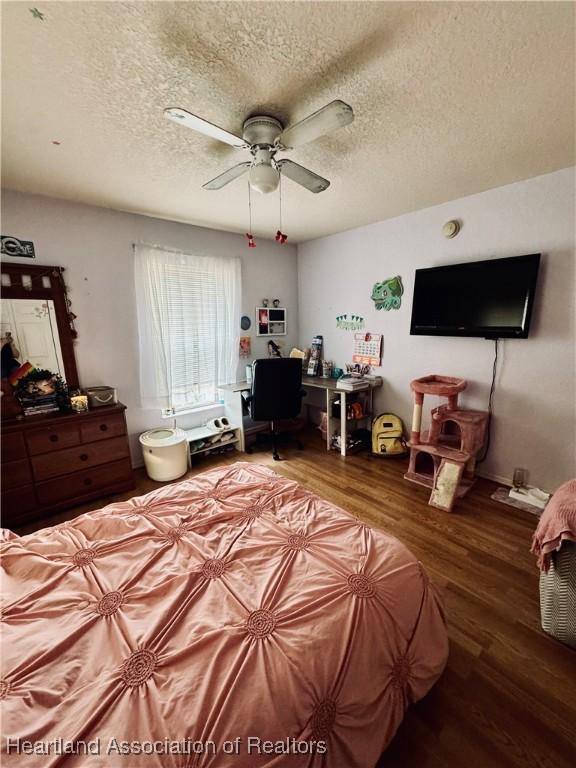 bedroom featuring wood-type flooring, ceiling fan, and a textured ceiling