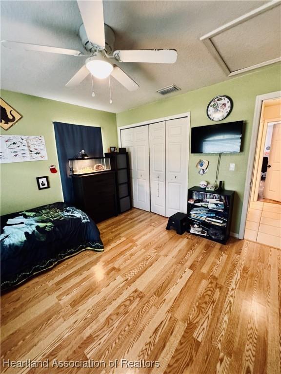 bedroom featuring light hardwood / wood-style flooring, a closet, and ceiling fan