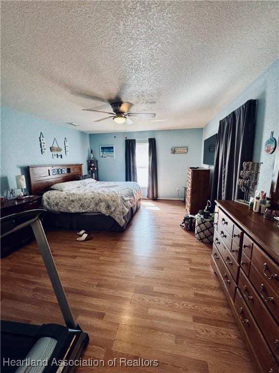 bedroom featuring ceiling fan, light hardwood / wood-style floors, and a textured ceiling