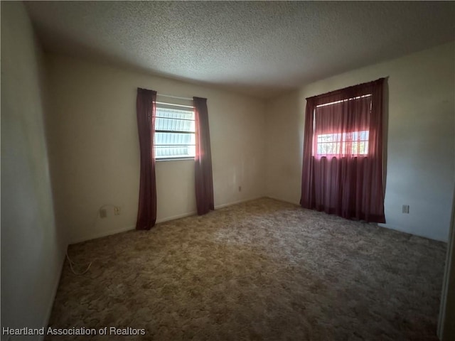 carpeted spare room with a textured ceiling