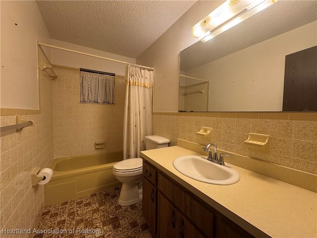 full bathroom with tile walls, vanity, toilet, a textured ceiling, and shower / bath combo with shower curtain