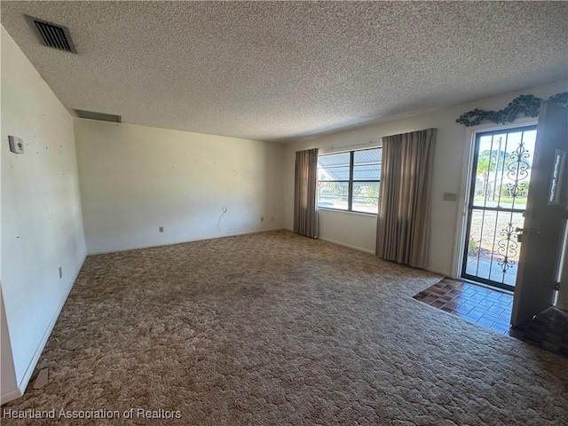 spare room with carpet flooring and a textured ceiling