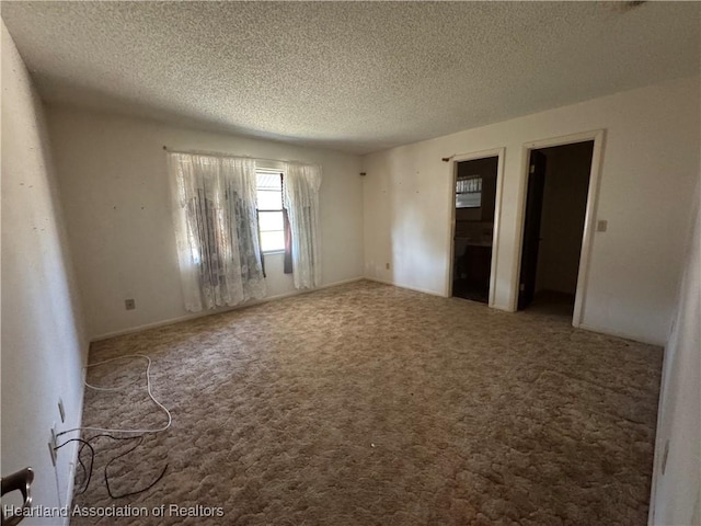 unfurnished room featuring carpet and a textured ceiling