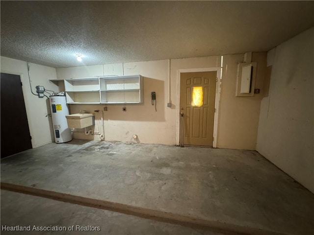 basement featuring electric panel, sink, water heater, and a textured ceiling