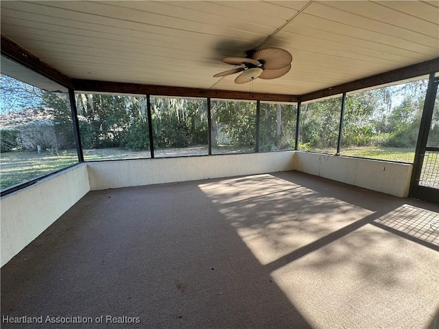 unfurnished sunroom with wooden ceiling and ceiling fan