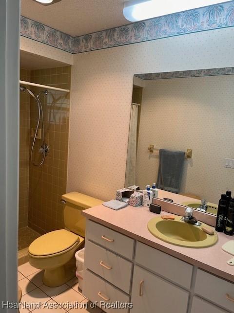 bathroom featuring tile patterned flooring, vanity, and curtained shower