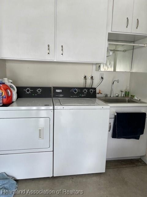 laundry area featuring washing machine and dryer, sink, and cabinets