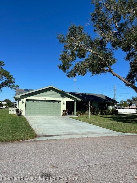 single story home with a garage and a front lawn