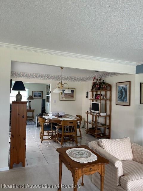 dining area with crown molding, light tile patterned floors, and a textured ceiling