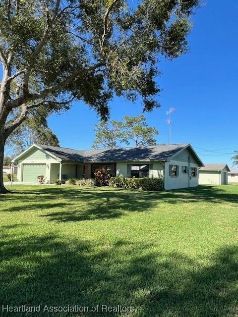 ranch-style home with a front yard and a garage