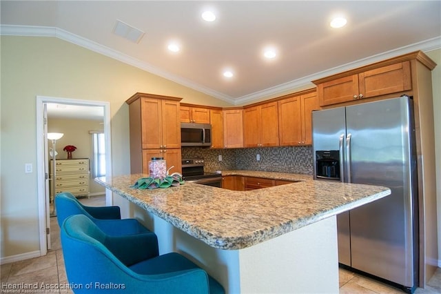 kitchen featuring appliances with stainless steel finishes, lofted ceiling, and a kitchen island with sink