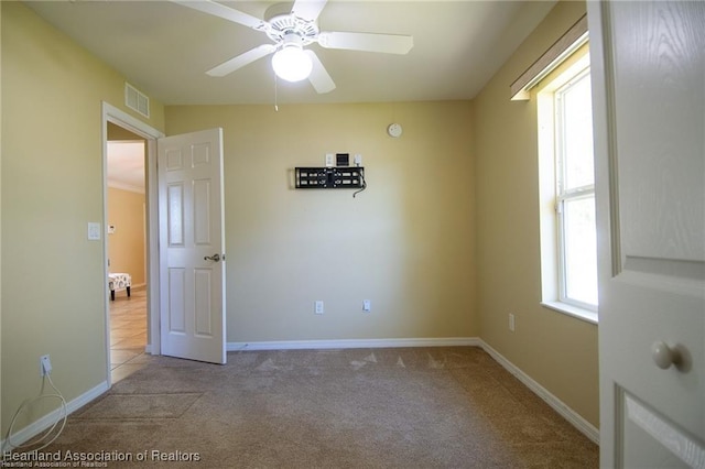 carpeted empty room featuring ceiling fan