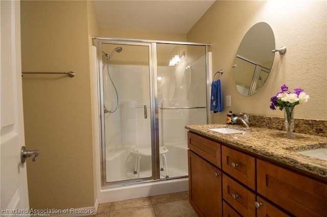 bathroom featuring a shower with shower door, vanity, and tile patterned flooring