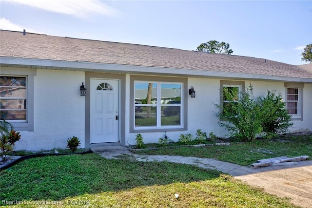 property entrance with a lawn