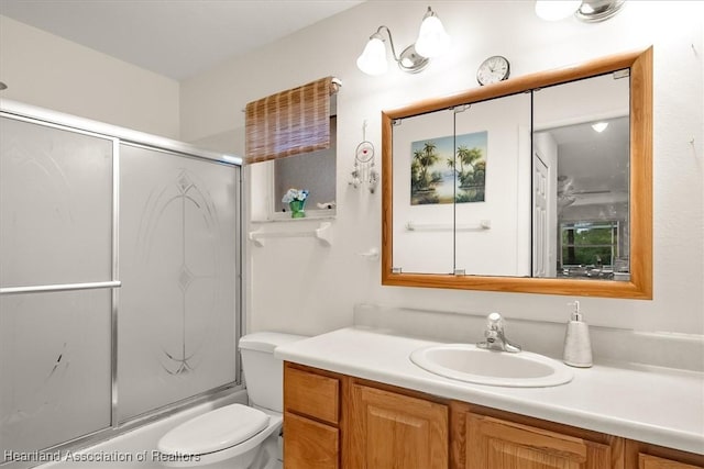 full bathroom featuring vanity, toilet, and enclosed tub / shower combo