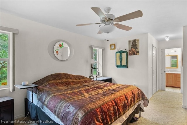 carpeted bedroom with ceiling fan and connected bathroom