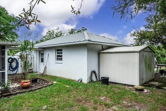 rear view of property featuring a shed and a yard