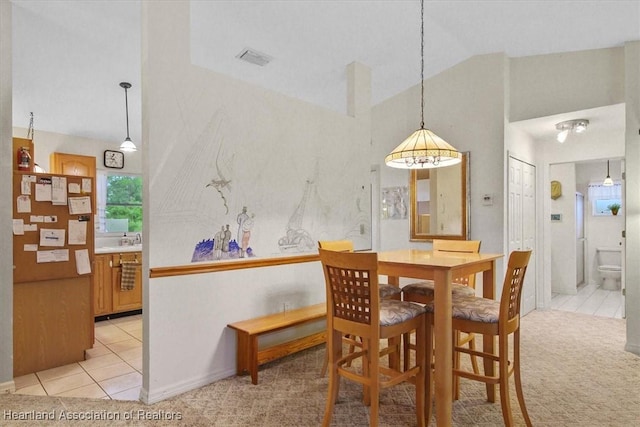 dining room featuring light colored carpet and lofted ceiling