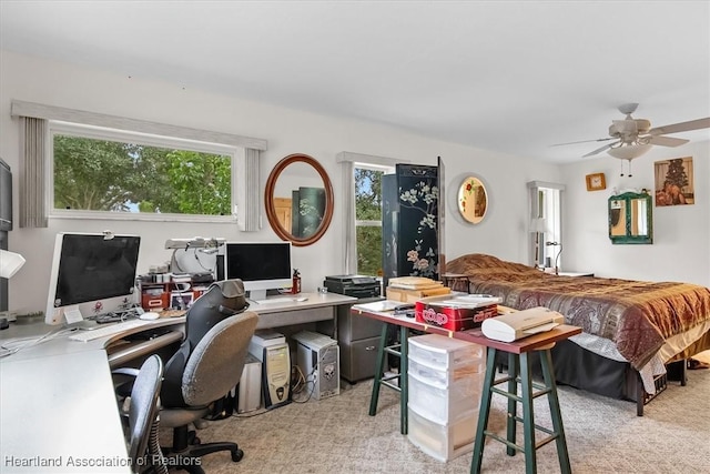 carpeted office space with ceiling fan