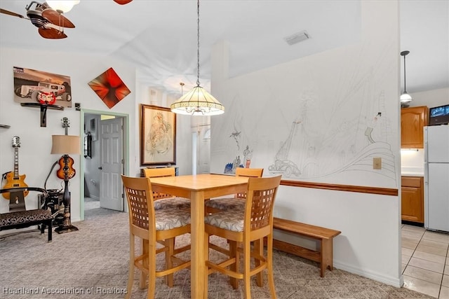 carpeted dining area featuring ceiling fan and lofted ceiling