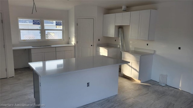 kitchen featuring white cabinets, a kitchen island, and sink