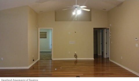 unfurnished room featuring high vaulted ceiling, hardwood / wood-style floors, and ceiling fan