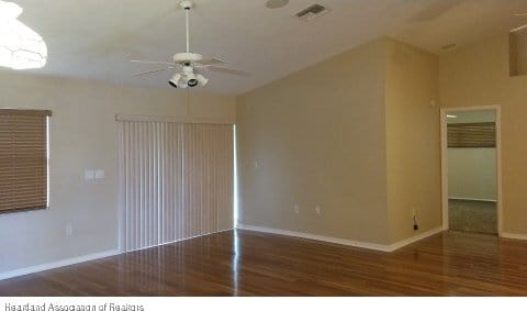 unfurnished room featuring ceiling fan and dark wood-type flooring