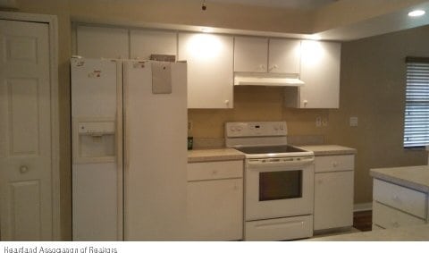 kitchen featuring white cabinetry and white appliances