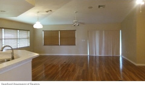 kitchen featuring ceiling fan, sink, dark hardwood / wood-style floors, lofted ceiling, and decorative light fixtures