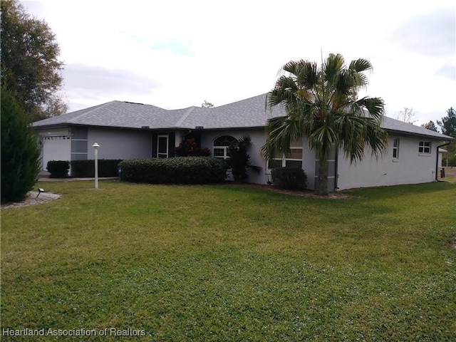 rear view of property featuring a lawn and a garage