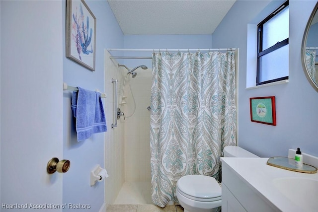 full bathroom featuring toilet, a tile shower, a textured ceiling, and vanity