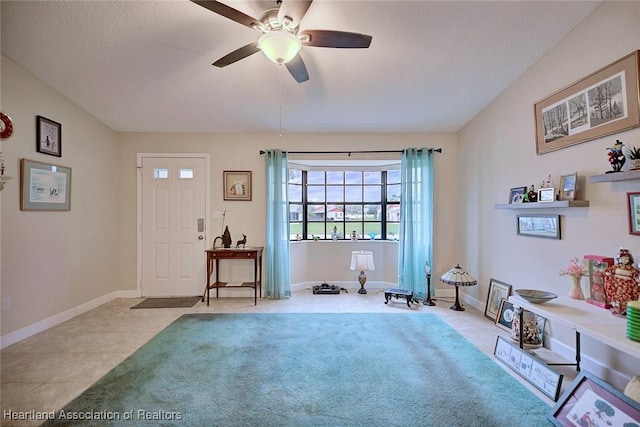 entrance foyer featuring ceiling fan, baseboards, a textured ceiling, and light tile patterned flooring