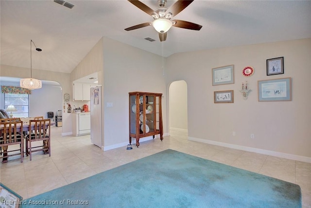 dining area featuring visible vents, arched walkways, vaulted ceiling, and light tile patterned flooring