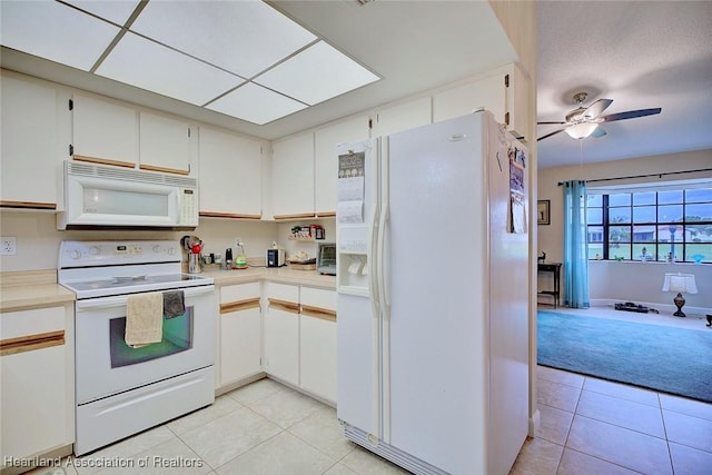 kitchen featuring white appliances, light countertops, and white cabinets