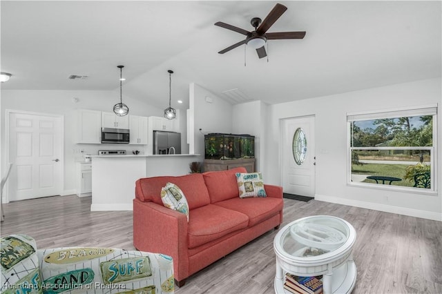 living room featuring ceiling fan, light hardwood / wood-style flooring, and lofted ceiling