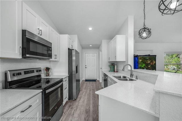 kitchen with white cabinets, decorative light fixtures, stainless steel appliances, and sink