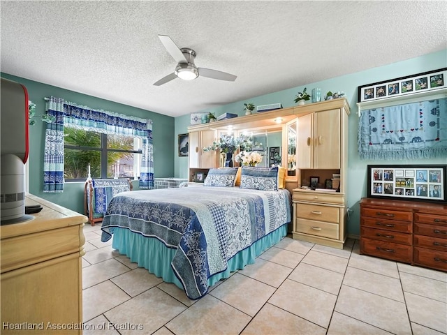 bedroom with ceiling fan, tile patterned flooring, and a textured ceiling