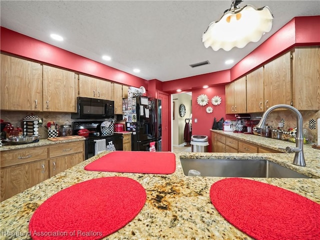 kitchen with decorative backsplash, sink, and black appliances