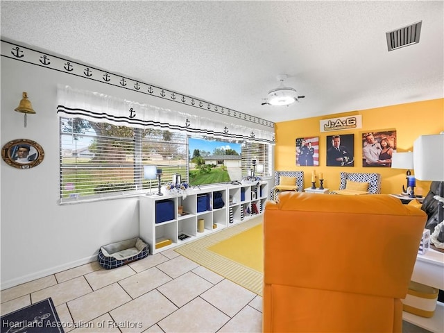 game room featuring light tile patterned flooring, a textured ceiling, and a wealth of natural light